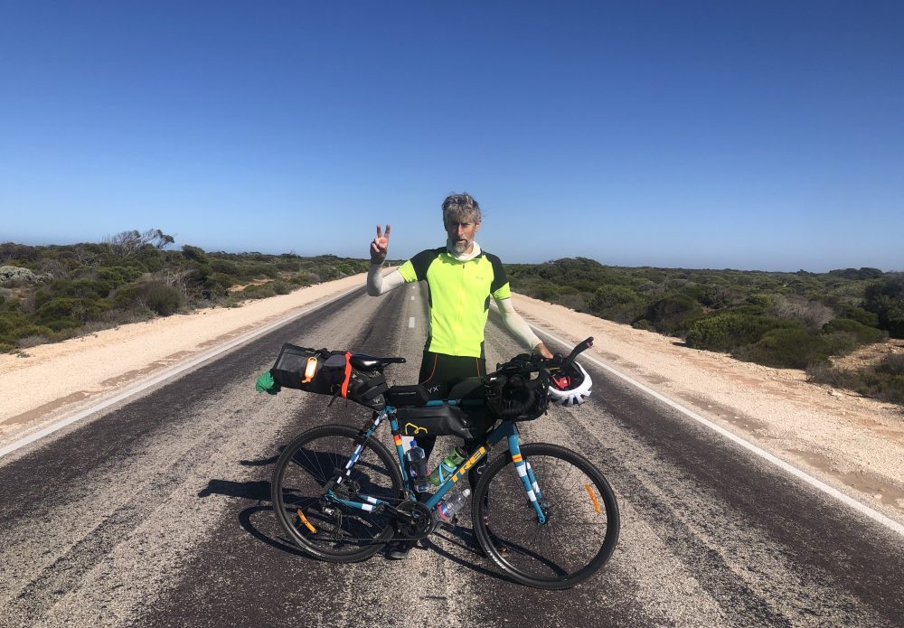 Edward Birt with his bikepacking bike in the middle of a road